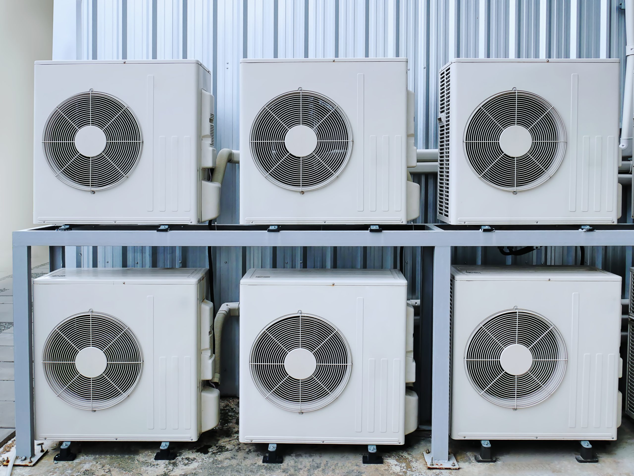 Row of air conditioning units mounted on an industrial building, highlighting energy management in commercial spaces.